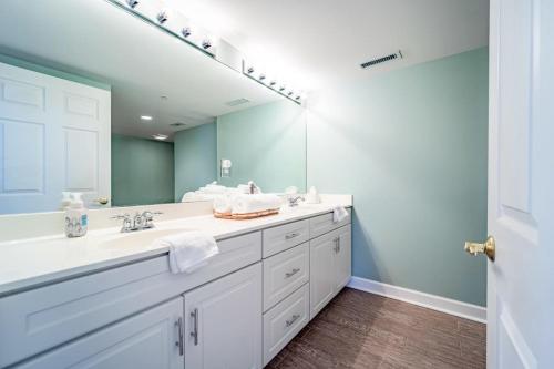 a bathroom with two sinks and a large mirror at Luxury Penthouse Apartment with Private Elevator in Ocean City
