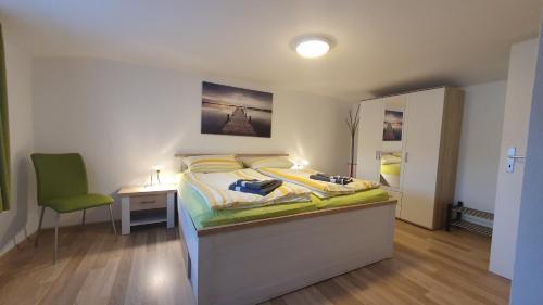 - une chambre avec un lit et une chaise verte dans l'établissement Ferienwohnungen Grüner Fürst, à Bad Muskau