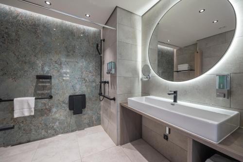 een badkamer met een wastafel en een spiegel bij Dolphin Suites & Wellness Curacao in Willemstad