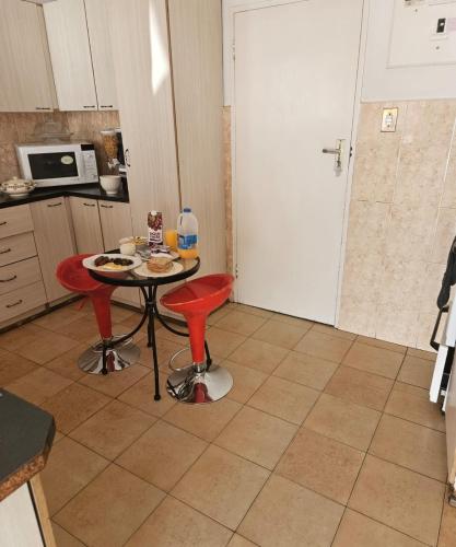 a small kitchen with a table and two red chairs at The Royal Princess B&B on Malibongwe Drive in Johannesburg