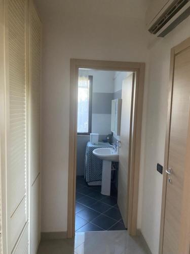 a bathroom with a sink and a mirror and a toilet at Casa al mare in Lascari