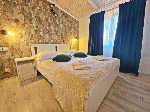 1 Schlafzimmer mit 2 Betten und einer Steinmauer in der Unterkunft Flamingo - House with private pool in Gornji Seget