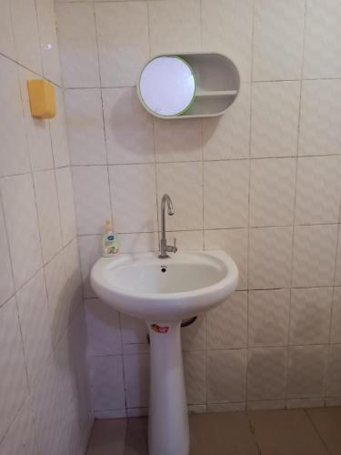 baño con lavabo y espejo en la pared en MaisonMina en Dakar