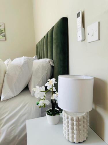 una lámpara blanca en una mesa junto a una cama en Unit B1 Motswedi Place, en Gaborone