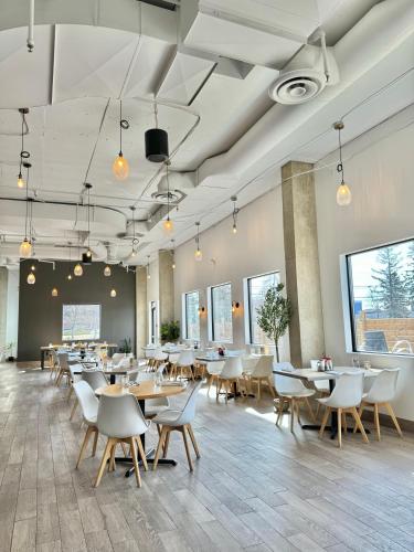 a dining room with tables and chairs at Divya Sutra Plaza and Conference Centre Calgary Airport in Calgary