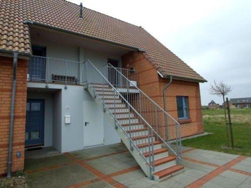 a staircase on the side of a house at Moderne Ferienwohnung mit Balkon in Strandnähe in Friedrichskoog