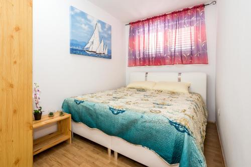 um pequeno quarto com uma cama e uma janela em Gušt em Sibenik