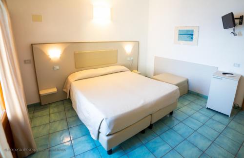 1 dormitorio con 1 cama blanca grande en una habitación en Hotel Saraceno, en Giglio Porto