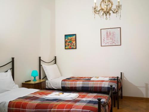 una camera con due letti e un lampadario a braccio di Affittacamere di Andrea Bertolino Bologna a Bologna