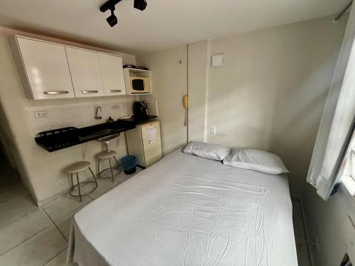 - une petite chambre avec un lit et un four micro-ondes dans l'établissement Prático 228, à Natal