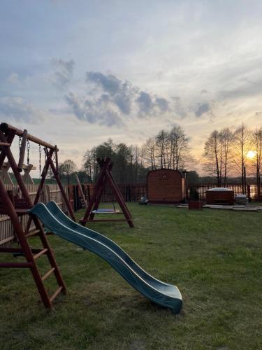 a playground with a slide in the grass at Słonecznikowe gniazdko in Miłomłyn