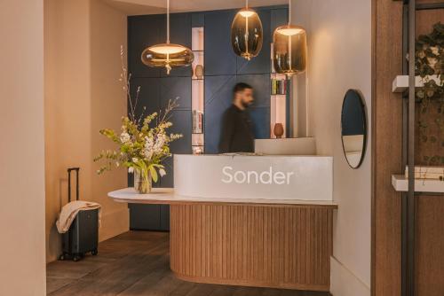 a sander counter in a store with a man in the background at Yelo Jean Médecin powered by Sonder in Nice