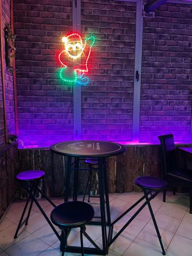 a table with a neon light hanging from a brick wall at Hotel Palma in Dragash