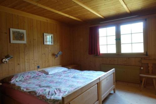 um quarto com uma cama num quarto de madeira em Bündnerchalet im Herz der Schweizer Alpen em Disentis