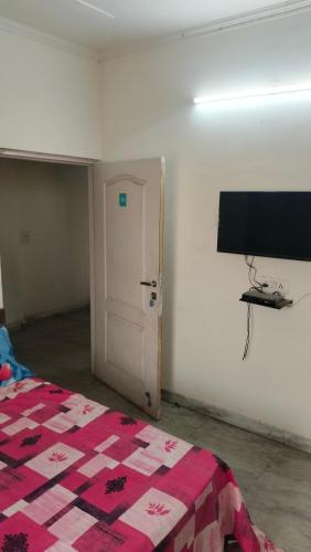 uma sala com um quarto com uma cama e uma porta em Bagpacker Stay em Faridabad