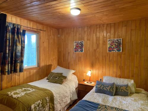 1 dormitorio con 2 camas y ventana. en Cabaña Casa Tetelhue, en Colliguay