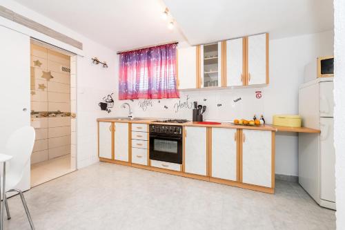 uma cozinha com armários de madeira e um lavatório em Gušt em Sibenik