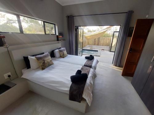 a bedroom with a large bed with a large window at House UmGanu in Marloth Park