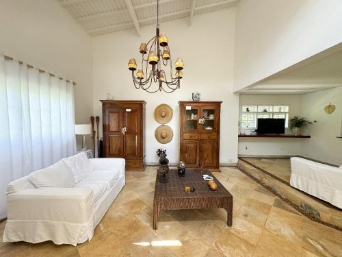 a living room with a white couch and a table at Casa com piscina privativa a 100m da Praia de Paúba in São Sebastião