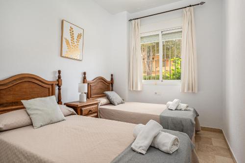 a bedroom with two beds and a window at Novo Atlántico Golf, Novo Sanctipetri in Novo Sancti Petri