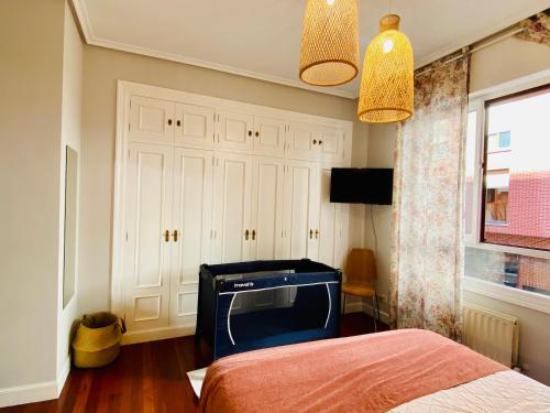 ein Schlafzimmer mit einem Bett und einem TV in der Unterkunft BilbaoBonito -Campo Volantin- Exterior 5min Guggenheim -Parking in Bilbao
