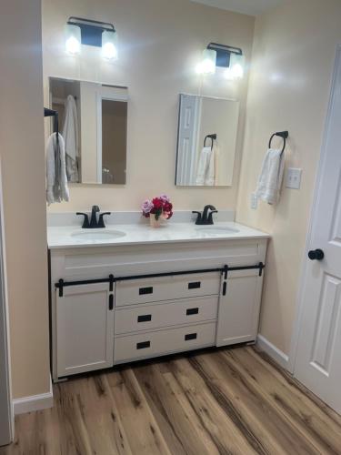 a bathroom with two sinks and two mirrors at Cottage style home close to golfing and lake 