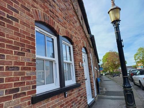 a street light next to a brick building with windows at Central Ripon - Sleeps 3 - Garden - Pet Friendly in Ripon
