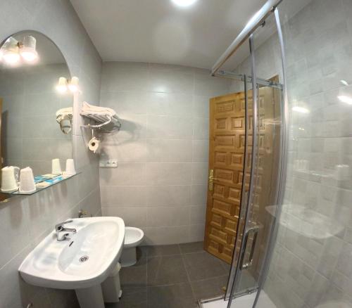 La salle de bains est pourvue d'un lavabo et d'une douche. dans l'établissement Apartamentos Javier, à Turieno