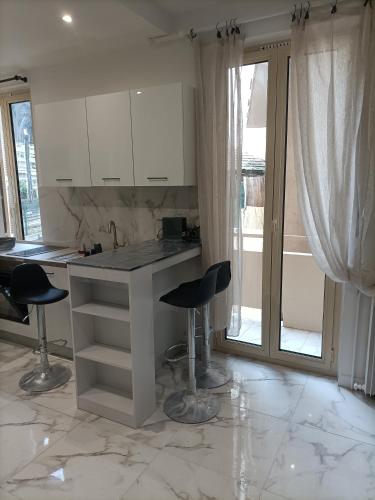 une cuisine avec un comptoir et deux tabourets de bar dans l'établissement Appartement confortable a proximite de la mer., à Nice