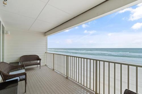 Un balcón con sillas y vistas al océano. en Sea Glass 405 by Vacation Homes Collection en Gulf Shores