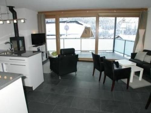 een keuken en een woonkamer met een tafel en stoelen bij Craista 5 in Scuol