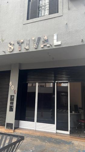 une entrée à un bâtiment avec un panneau sur celui-ci dans l'établissement Suites Stival Centro, à Goiânia