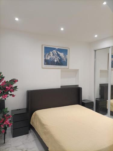 une chambre avec un lit et un tableau au mur dans l'établissement Appartement confortable a proximite de la mer., à Nice
