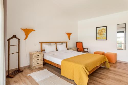 um quarto com uma cama com um cobertor amarelo em Casa do Vale em Chelreira