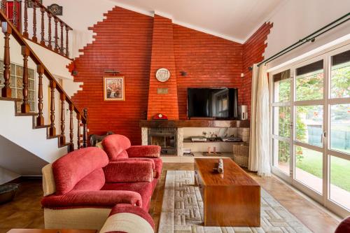 una sala de estar con una pared de ladrillo rojo en Casa do Vale, en Chelreira