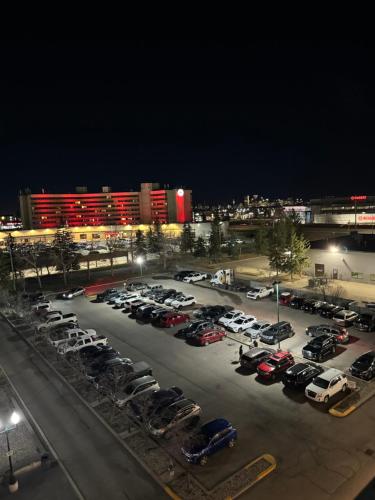 a parking lot with cars parked in it at night at Divya Sutra Plaza and Conference Centre Calgary Airport in Calgary