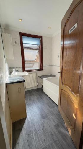 małą łazienkę z wanną, umywalką i wanną w obiekcie 25 Minutes to Central London Rooms 35 w Londynie