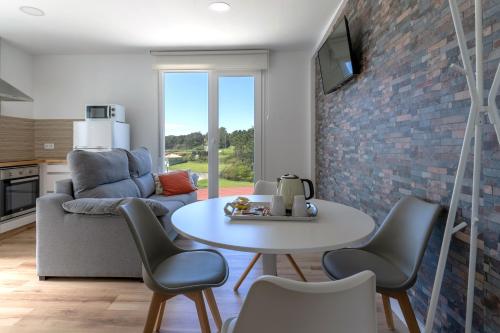 a living room with a table and chairs at Hospedium Apartamentos Galitrips A Casa Da Reina in Muxia