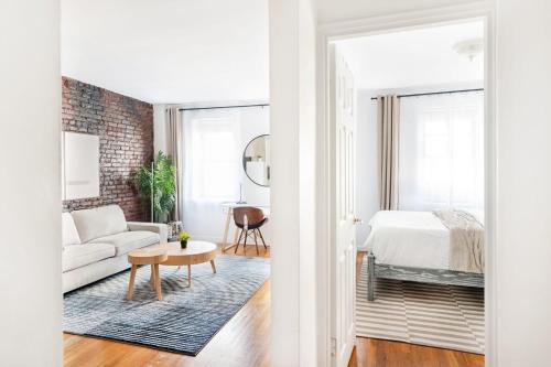 una sala de estar blanca con una pared de ladrillo en 350-1A Gramercy New 1BR Sleeps4 Newly Furnished, en Nueva York