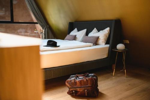 1 dormitorio con 1 cama y 1 maleta en el suelo en Villa mit Pool, Whirlpool, Sauna und großem Privatgarten, en Caldaro