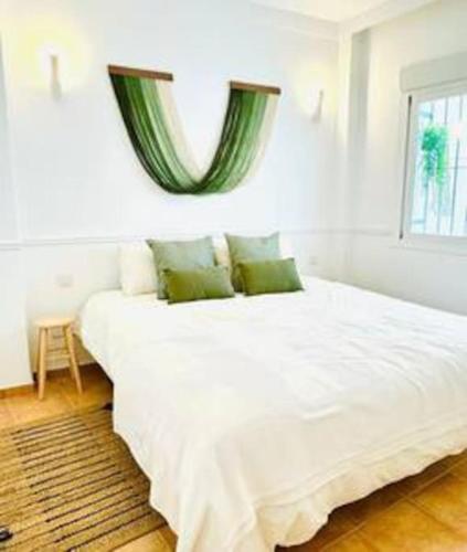 a bedroom with a large white bed with a window at Logement vieux centre Marbella in Marbella