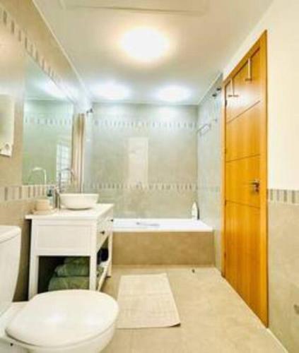 a bathroom with a toilet and a sink and a tub at Logement vieux centre Marbella in Marbella