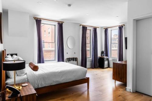 a bedroom with a bed and some windows at Canal View, DTWN Bangor, Steps to great Restaurants, Room # 210 in Bangor