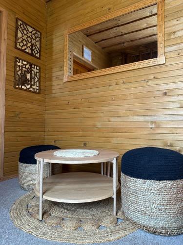 a room with a sauna with a table and two stools at Rakši in Cēsis