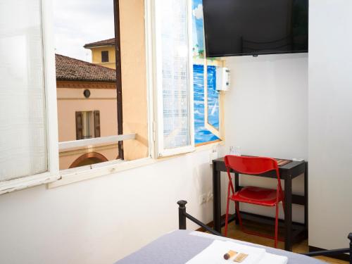 una sedia rossa in una stanza con finestra di Affittacamere di Andrea Bertolino San Lazzaro di Savena a San Lazzaro di Savena