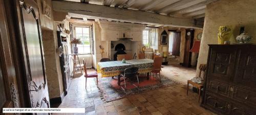 a living room with a table and a fireplace at Nouveau! Propriété historique avec piscine, proche châteaux de la Loire et Futuroscope in Les Ormes