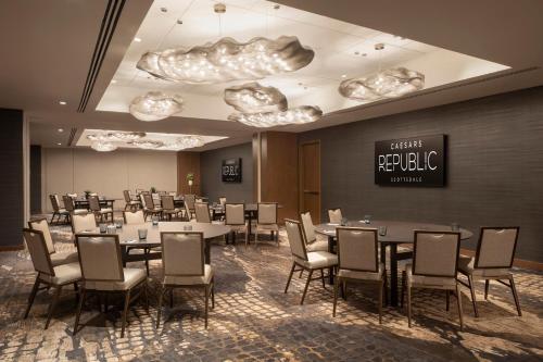 a conference room with tables and chairs and a sign at Caesars Republic Scottsdale, a Hilton Hotel in Scottsdale