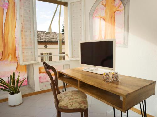 Habitación con mesa de madera, TV y ventana. en Affittacamere di Andrea Bertolino San Lazzaro di Savena, en San Lazzaro di Savena