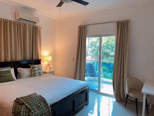 um quarto com uma cama e uma porta de vidro deslizante em Apartamento a pasos de la playa em Punta Cana