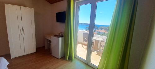 a room with a window with a view of the ocean at Apartments & rooms Mila in Banjol